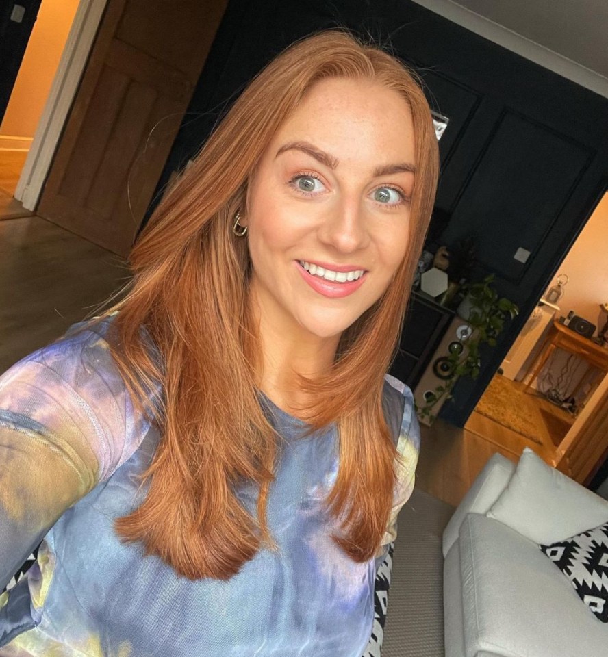 Woman with long red hair smiling for the camera.