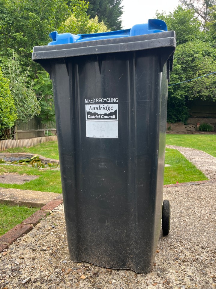 Black recycling bin with a blue lid.