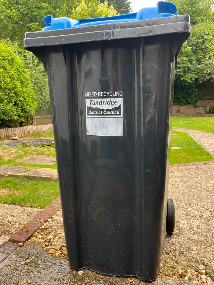 Black recycling bin with a blue lid.