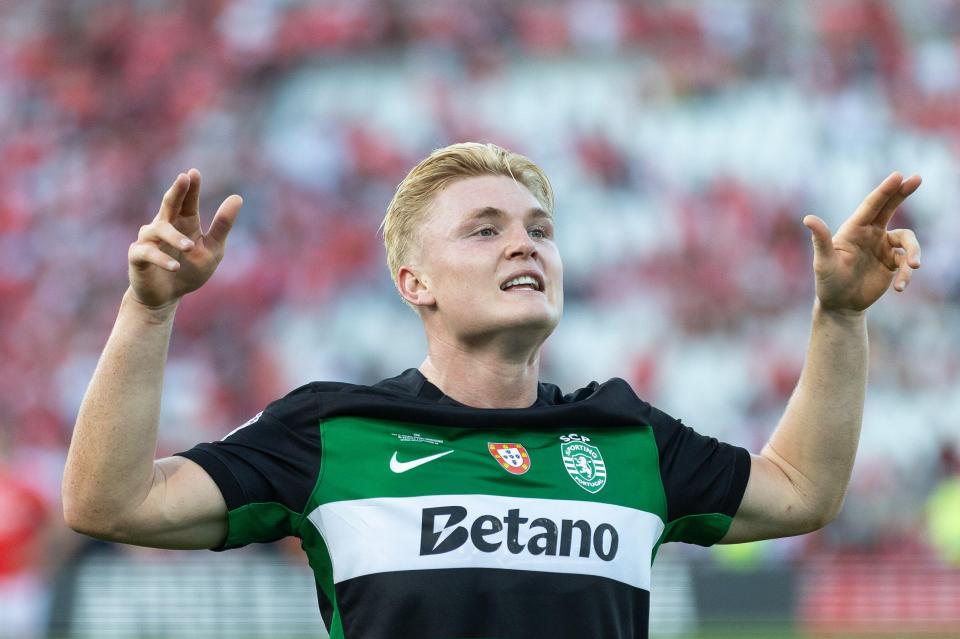 Sporting CP player celebrating a teammate's goal.