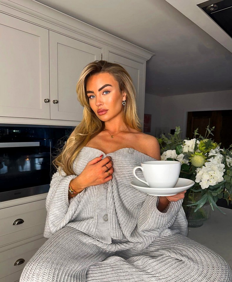 Woman in gray sweater holding a teacup.