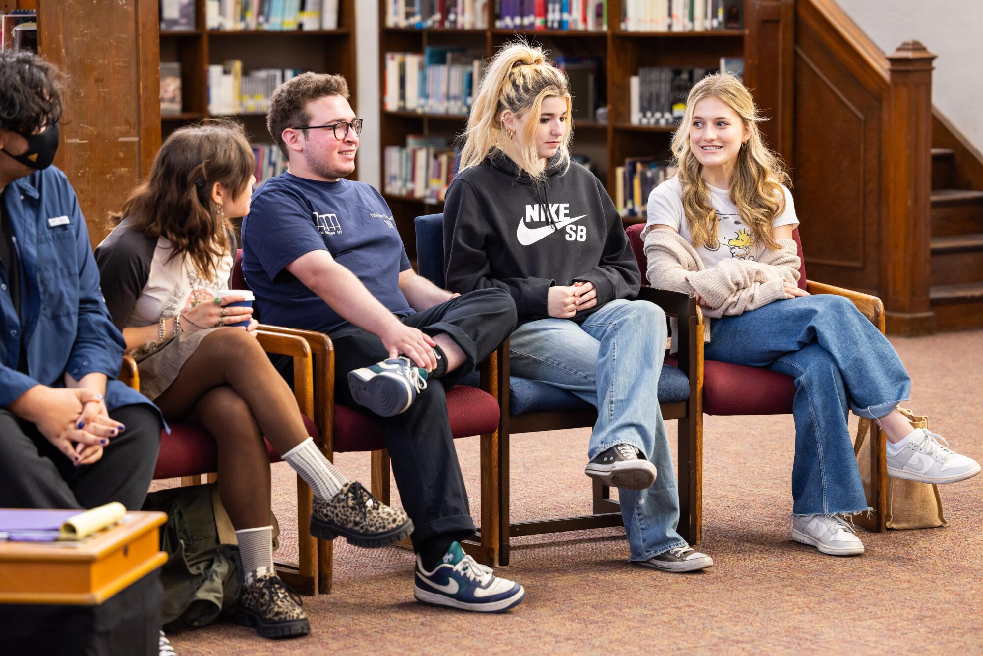 Students sitting in a semi-circle in a library.