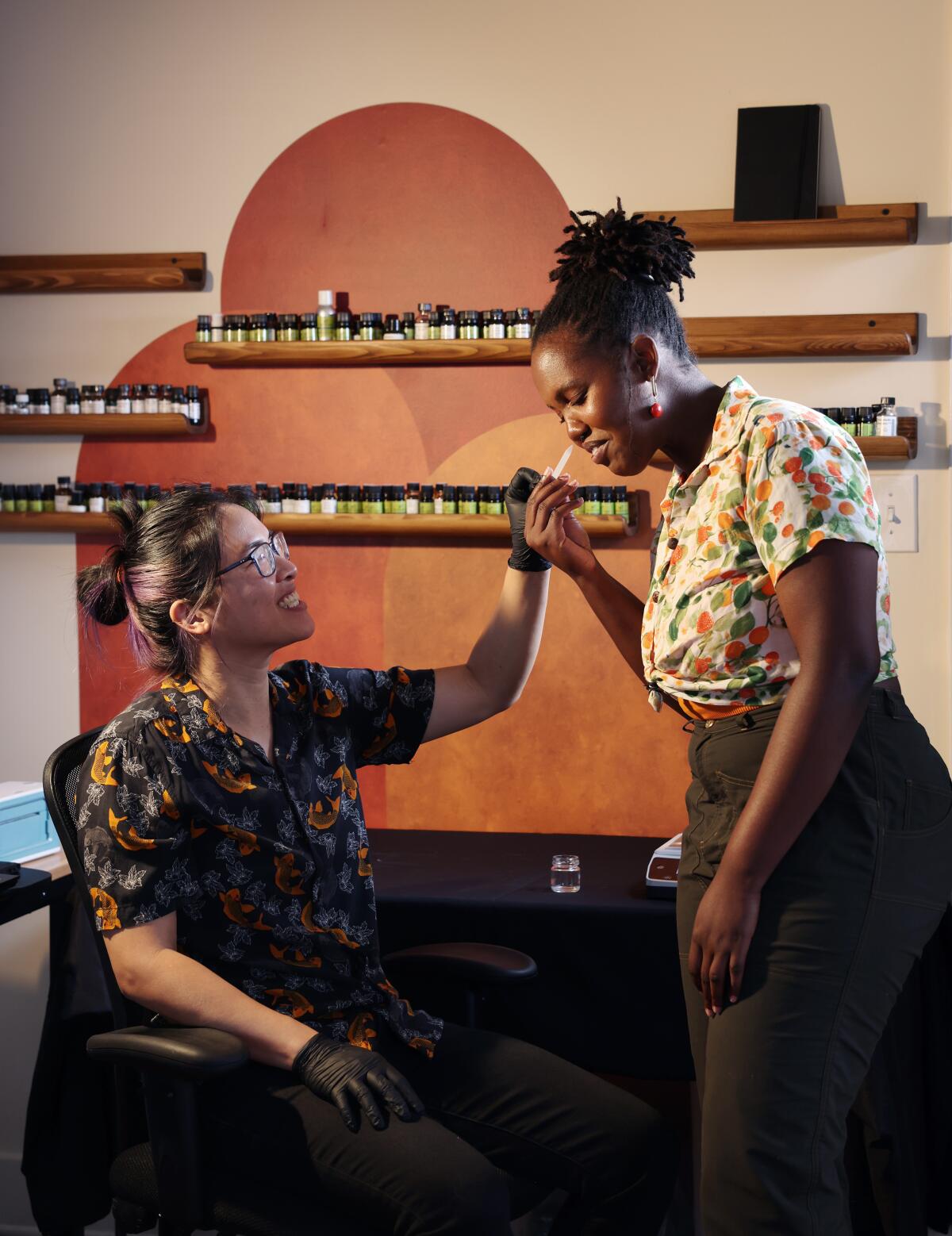 Lawrence, right, smells a sample fragrance. Lawrence and Lin are partners in both work and life.