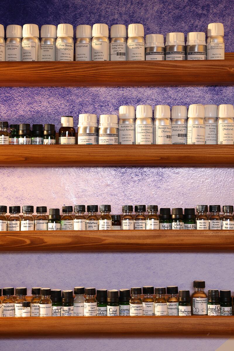 Shelves lined with bottles of essential oils and aromachemicals.