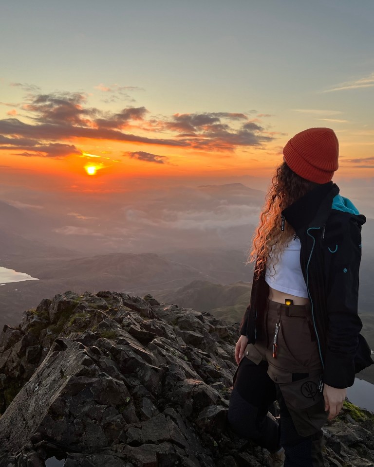 Woman on mountaintop at sunset.