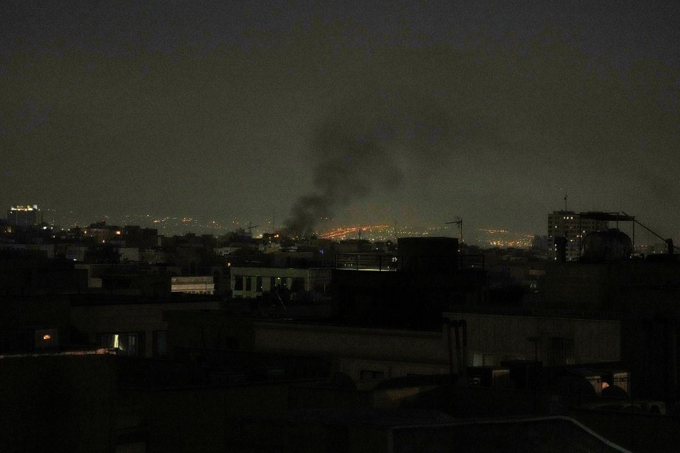 Smoke rising over Tehran at night.