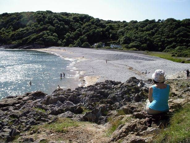Woman looks down on beach scene
