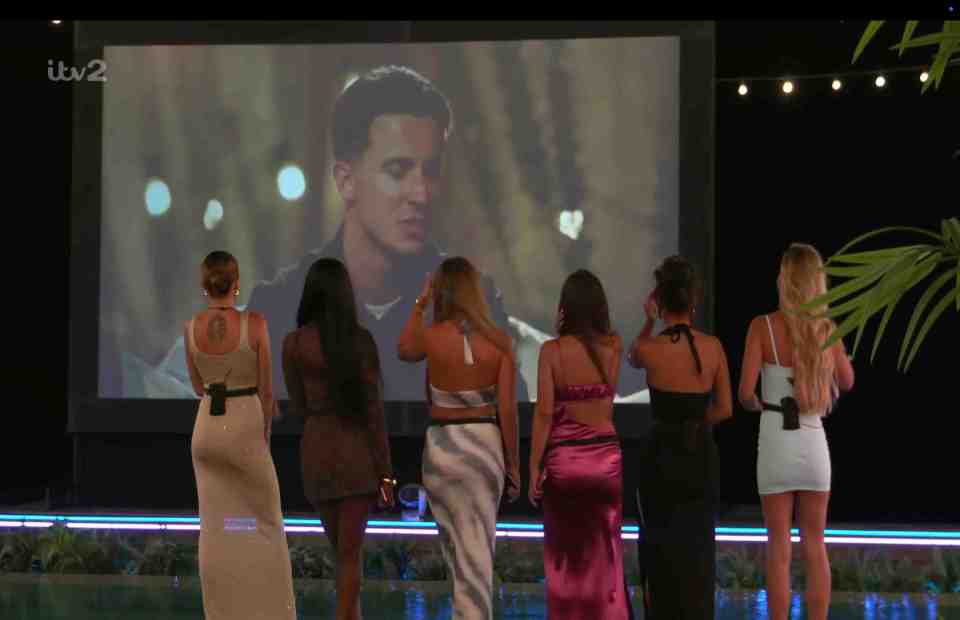 Women watching men on a large screen.