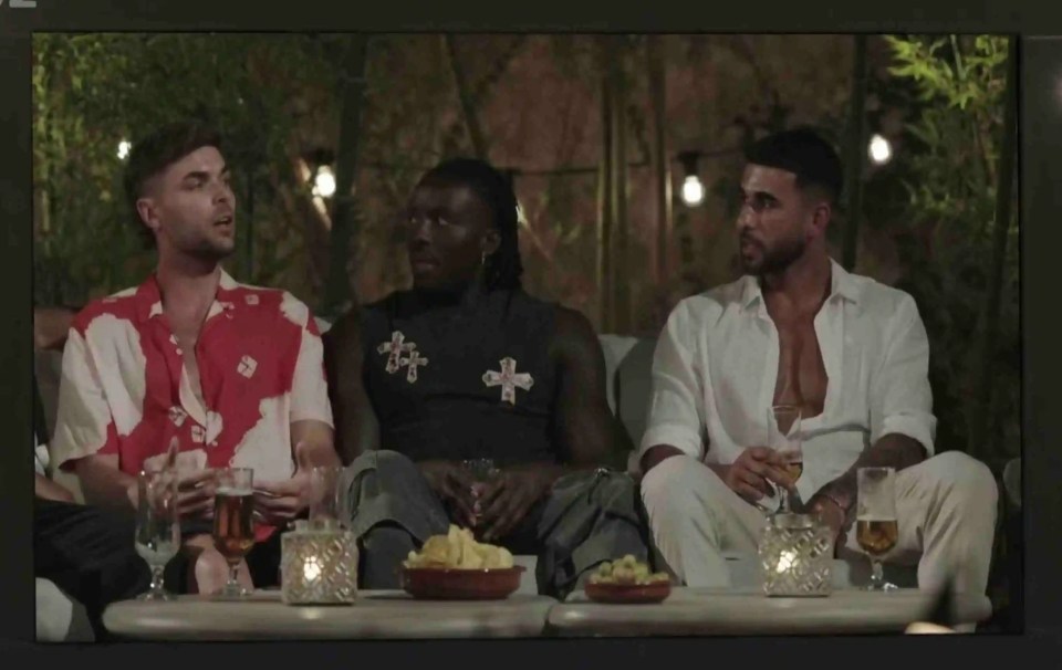 Three men watching a screen.