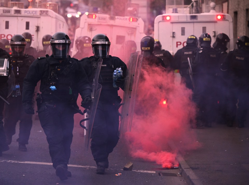 Police officers in riot gear during a civil unrest.