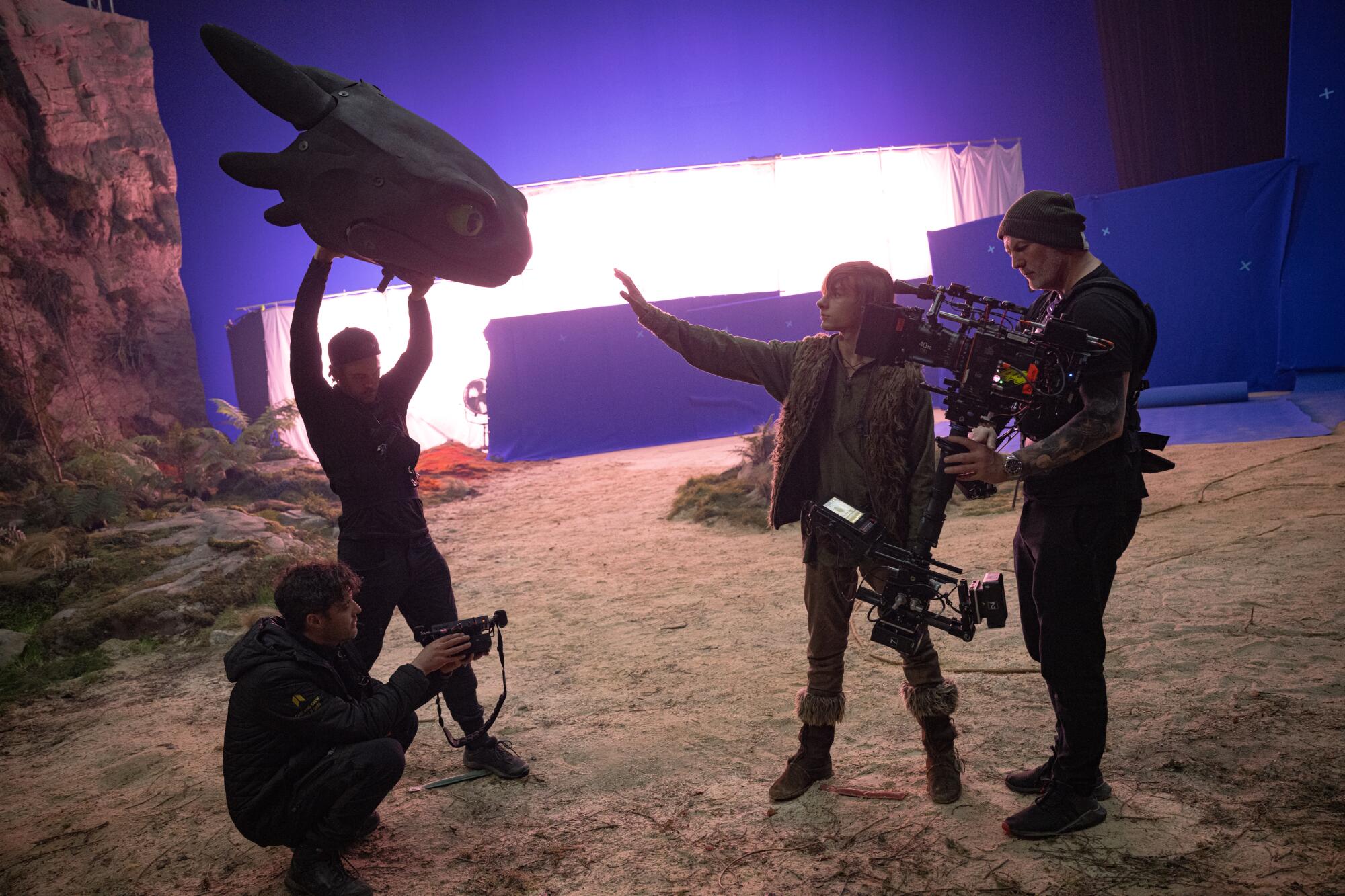 An actor plays a scene with a puppet of a dragon head.