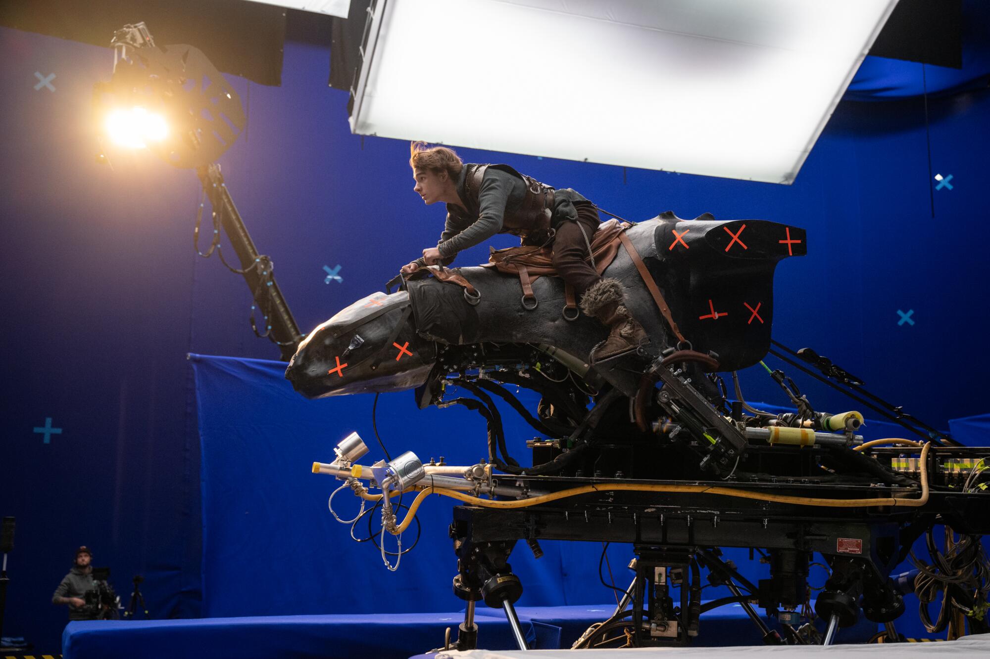 An actor sits on an animatronic dragon.
