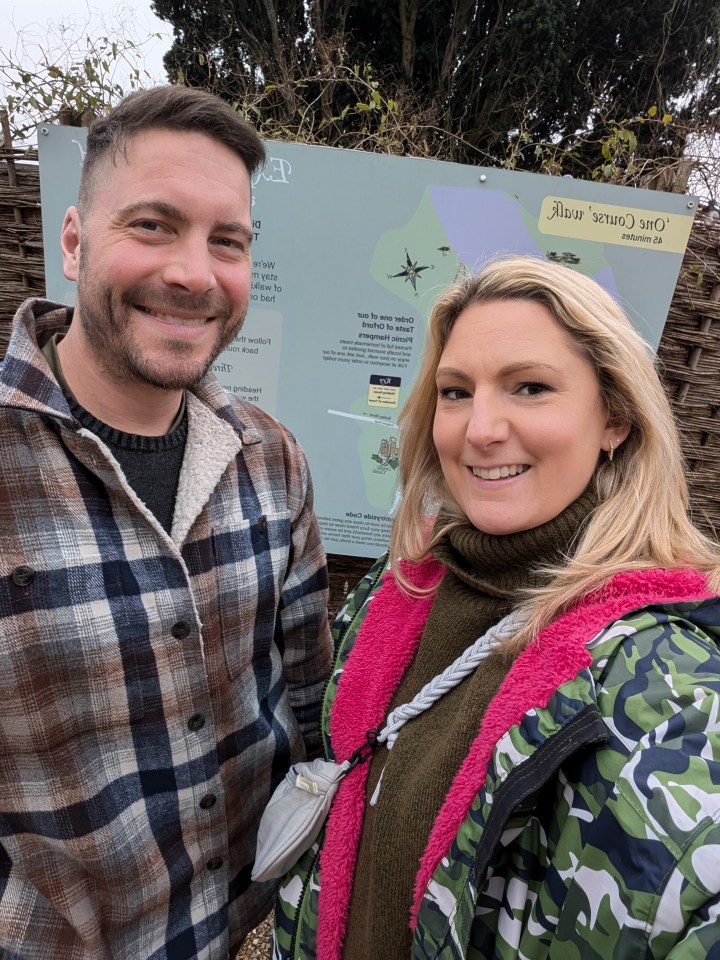 Portrait of a couple in front of a sign.