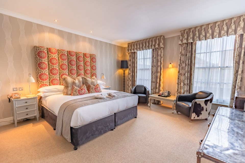 Hotel room with king-size bed and seating area.