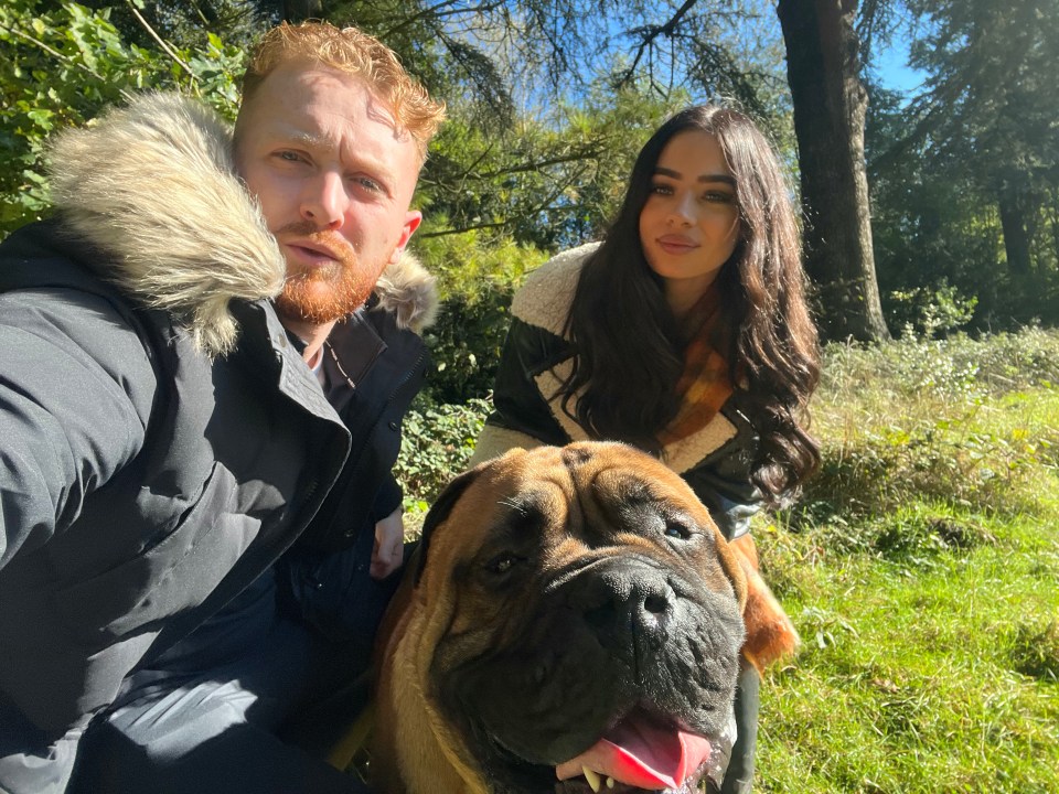 A couple and their dog in a park.