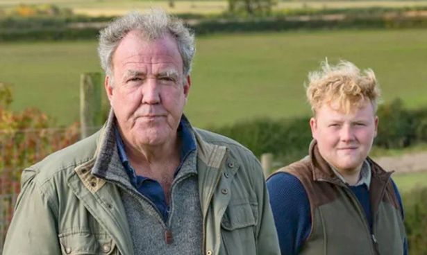 Two men stand in a field
