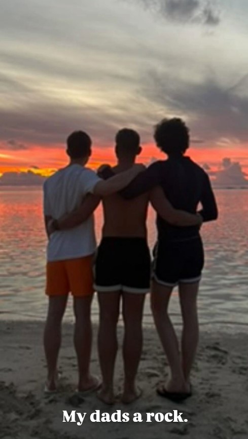 Three brothers standing on a beach at sunset.  "My dad's a rock."