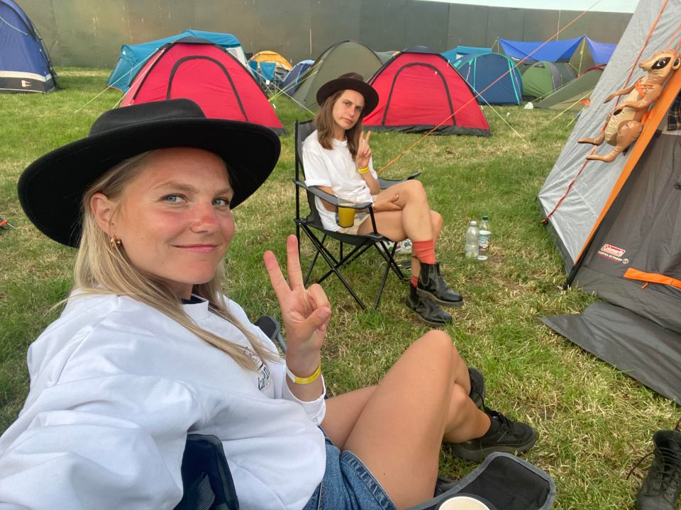Two women sitting in camping chairs at a festival.