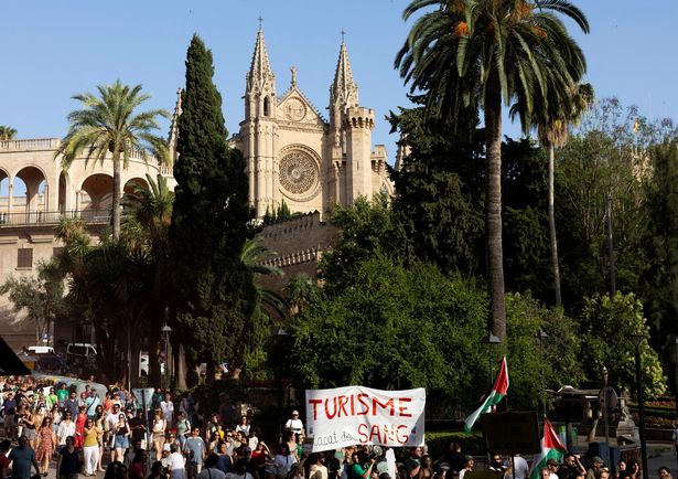 Demonstrators take part in a protest against overtourism and housing prices next to the Cathedral of Palma de Mallorca, on the Balearic island of Mallorca on June 15, 2025. (Photo by JAIME REINA / AFP) (Photo by JAIME REINA/AFP via Getty Images)