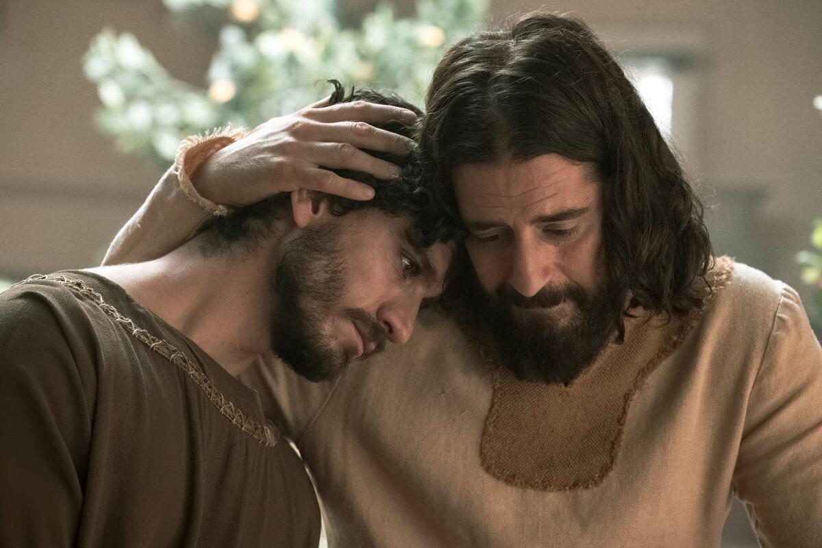 A man cradling the head of another man in an embrace 