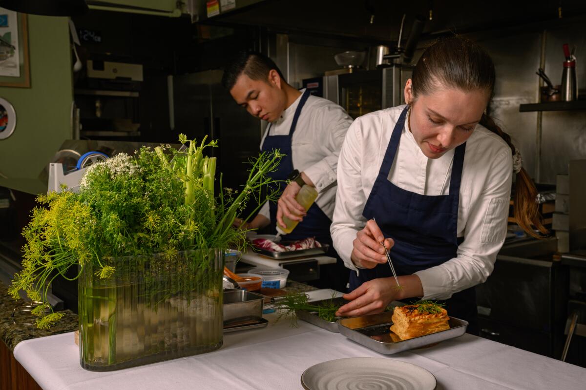 HERMOSA BEACH, CA - JUNE 7, 2025: Chef Kevin de los Santos and Chef Katya Shastova plating in the kitchen at Vin Folk