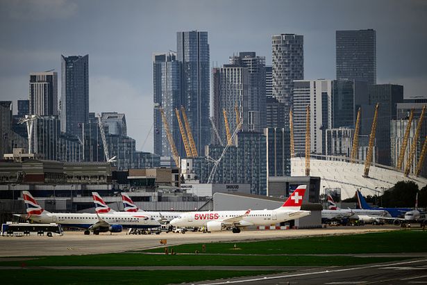 Image of planes taxied at London City Airport with skyscrapers in the background