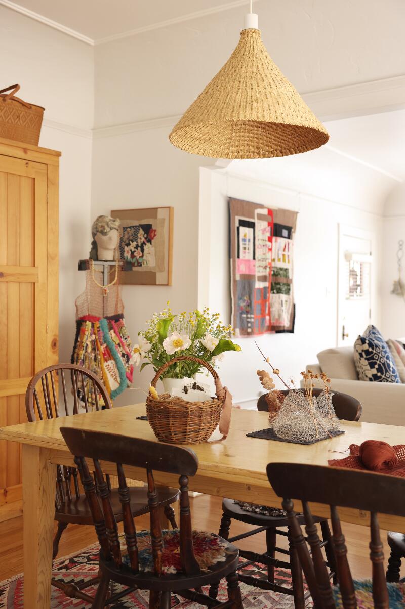 A dining room table and walls lined with art 