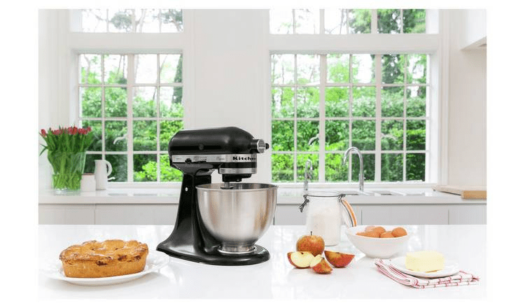 Black KitchenAid stand mixer with ingredients for baking.