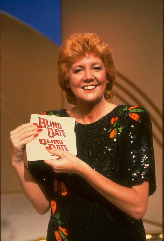 Cilla Black holding a Blind Date card on the set of the game show.
