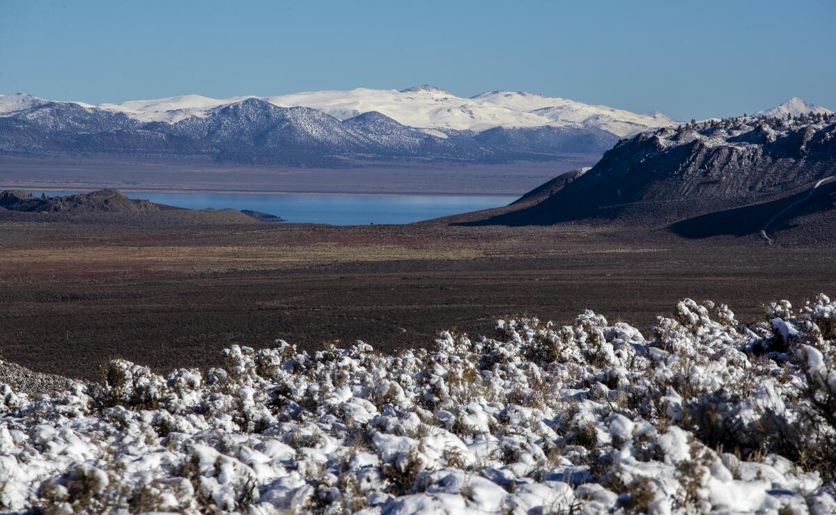 Snow covered peaks and sagebrush frame a view of Mono Lake.