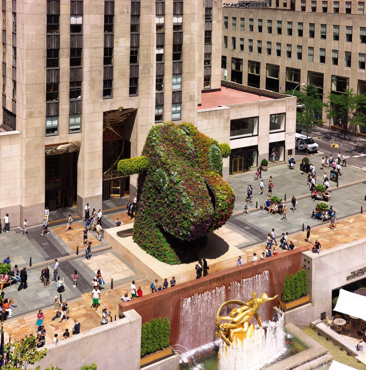 A large topiary sculpture of two toy rockers — a horse and a dinosaur — split in half and paired unevenly down the middle.