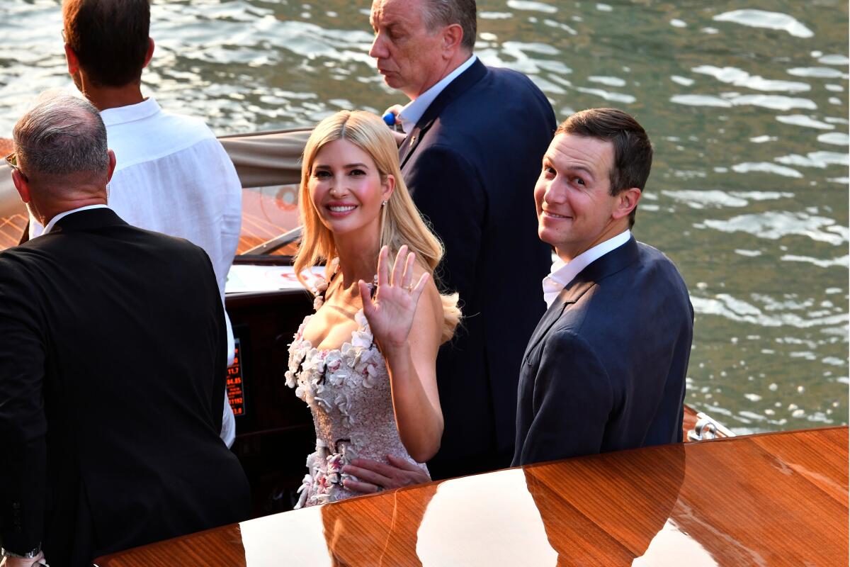 Ivanka Trump, standing next to husband Jared Kushner, waves from a boat.
