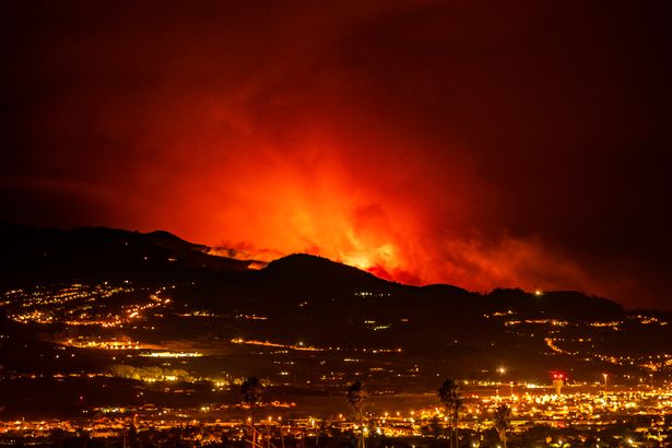 Flares are seen on the horizon as the fire advances through the forest toward the town of La Laguna and Los Rodeos airport in Tenerife, Canary Islands,