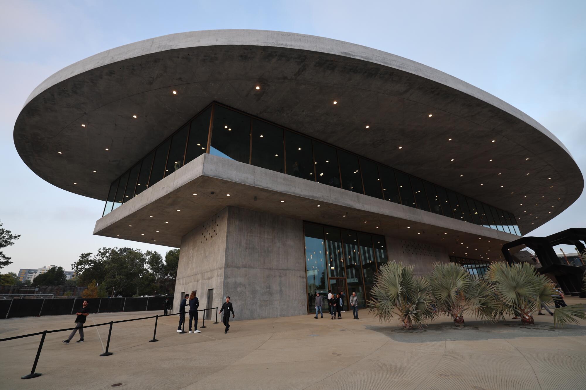 The ground view up toward the new LACMA building shows a curvaceous top form contrasted with rectilinear lines below.