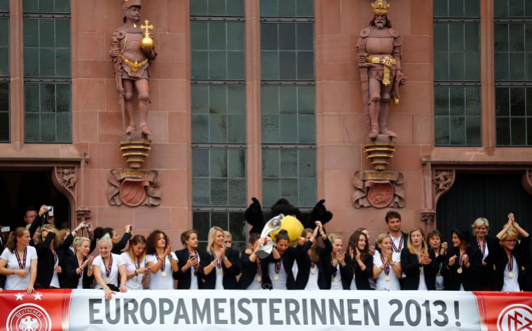 Players of Germany's women's national soccer team present the European Championship trophy during a reception on the balcony of the town hall in Frankfurt, July 29, 2013. Germany defeated Norway 1-0 in the European women's soccer championship with goalkeeper Nadine Angerer (3rd R) saving two penalties in the final. REUTERS/Kai Pfaffenbach (GERMANY - Tags: SPORT SOCCER)