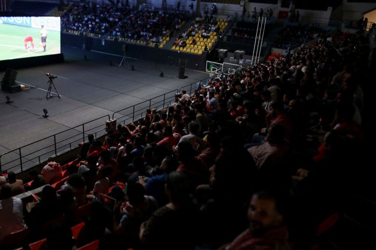 Jordanians watch their national football team play against Oman on screen, as Jordan qualified for World Cup for the first time after 3-0 win over Oman