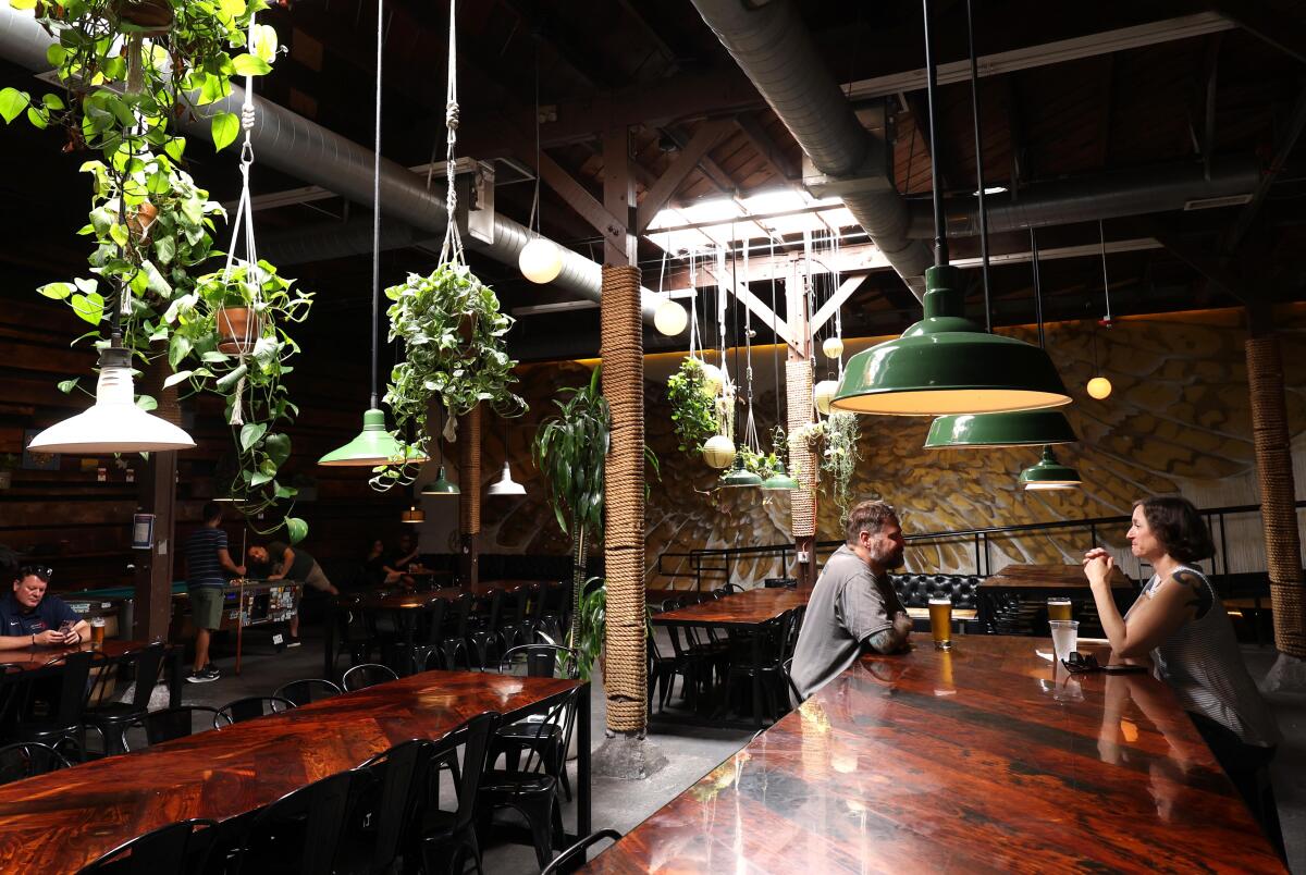Two people drink at an empty bar.