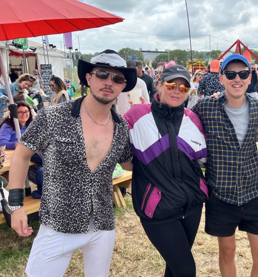 Three people posing for a photo at a festival.