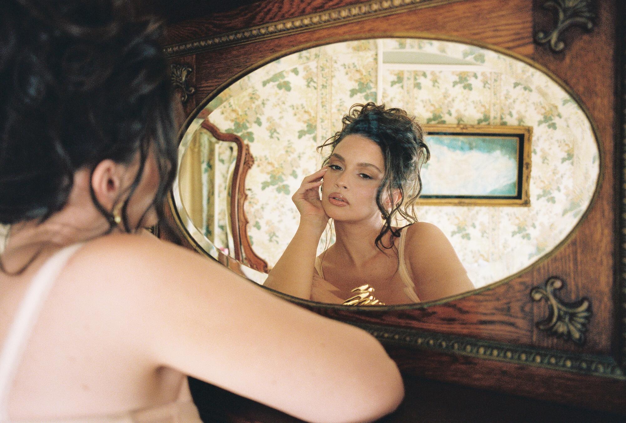 Sabrina Claudio looking at herself in a mirror