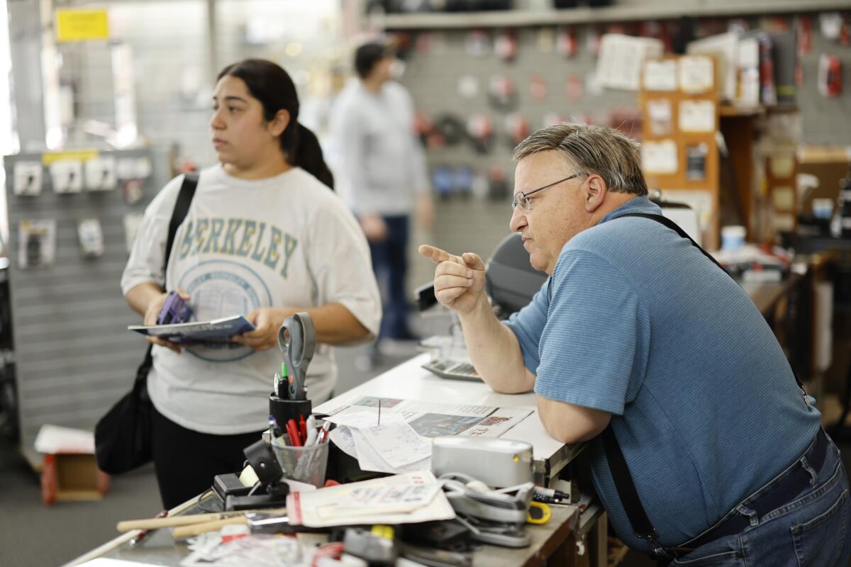 Ed Intagliata directs Wendy Flores to the music book section.