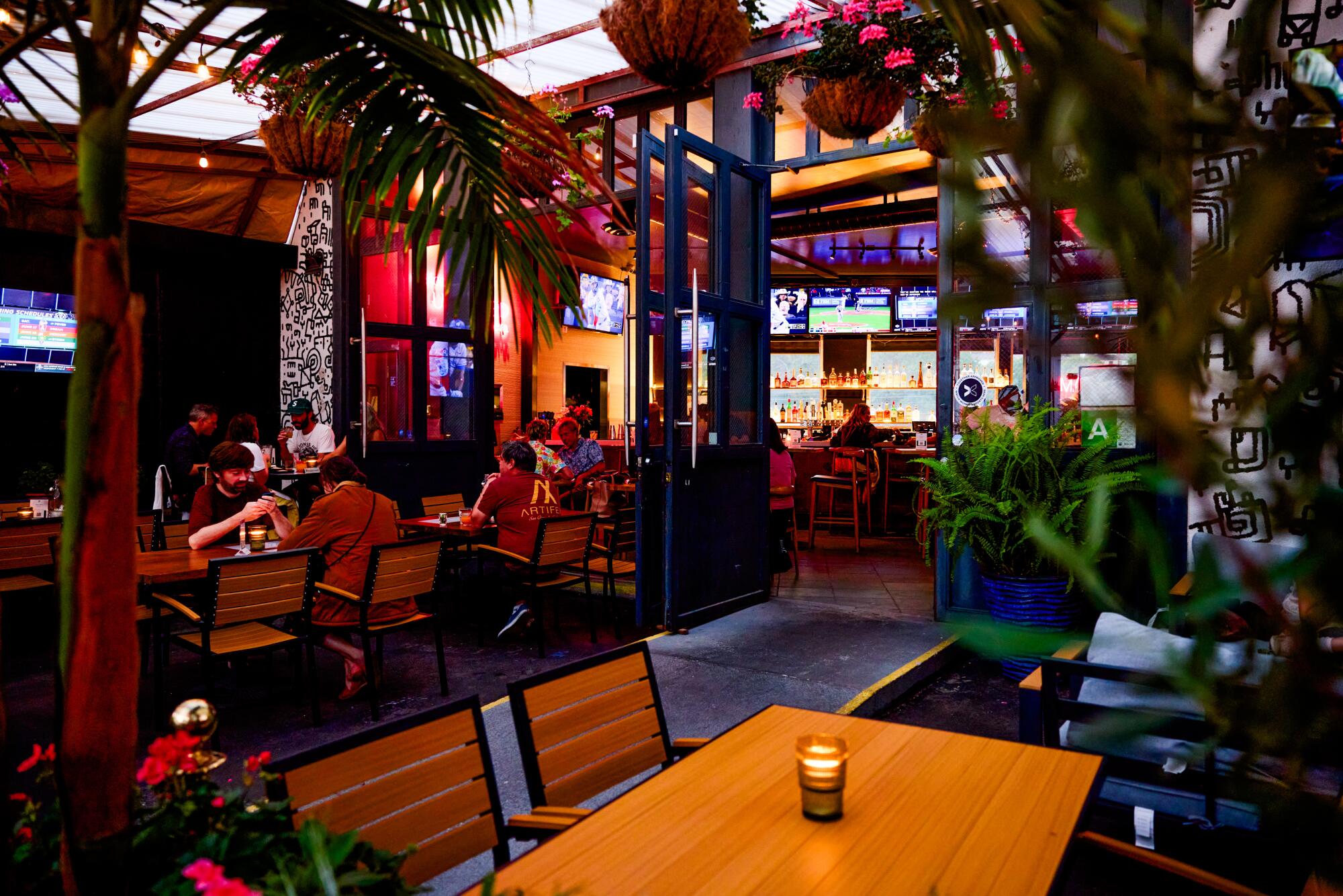 Inside a bar with greenery and flowers.