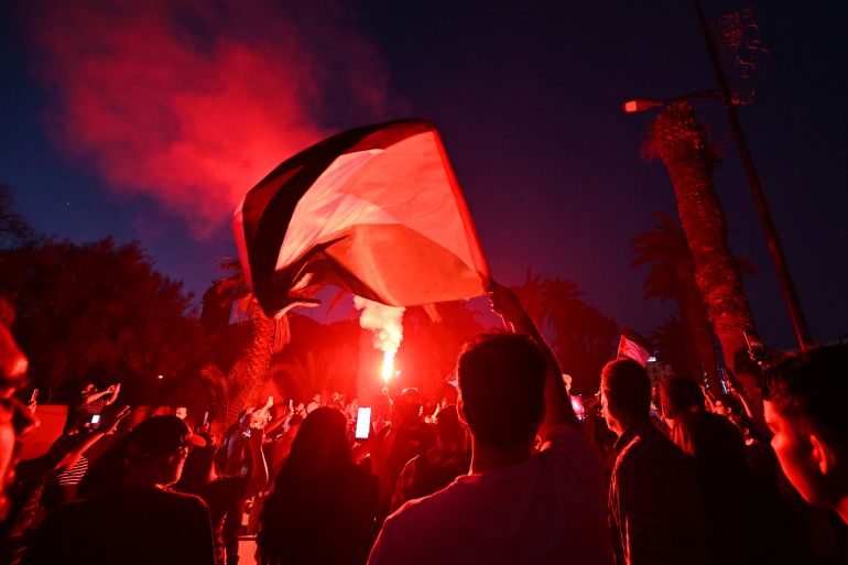 Tunisians wave the Palestinian flag as they gather at a meeting point in Tunis early on June 9, 2025, ahead of the departure of a land convoy named “Steadfastness” to break the siege on Gaza.
