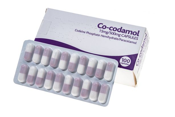 Image of a box of co-codamol tablets next to a leaf containing two rows of 10 capsules
