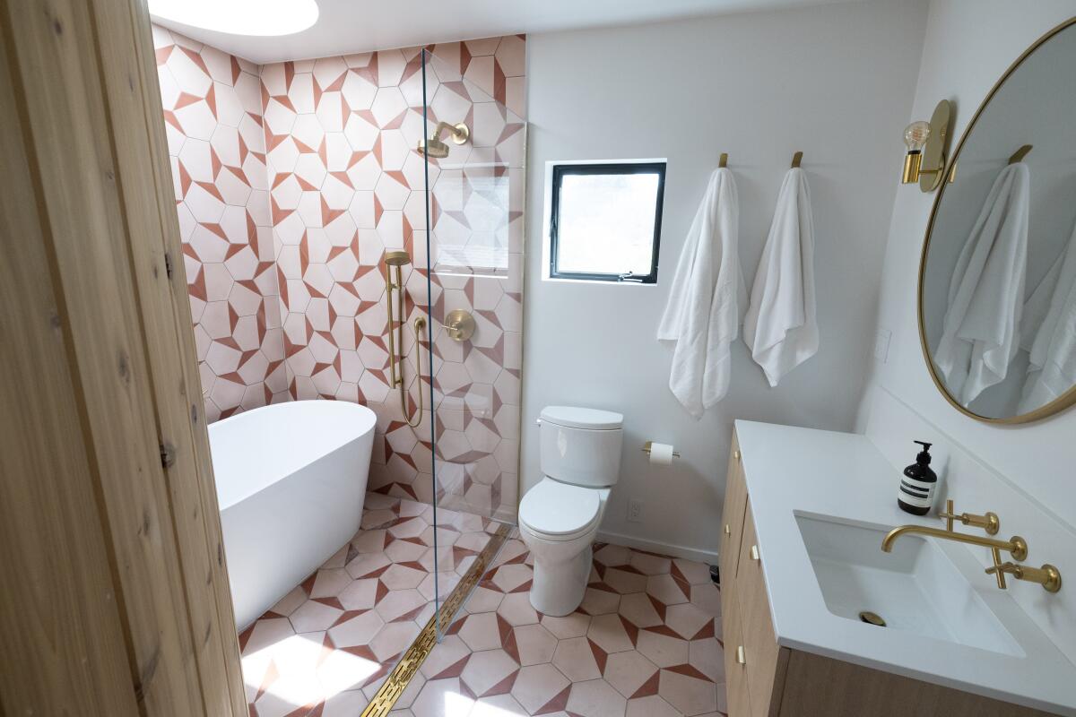 A bathroom with pink and red graphic tile