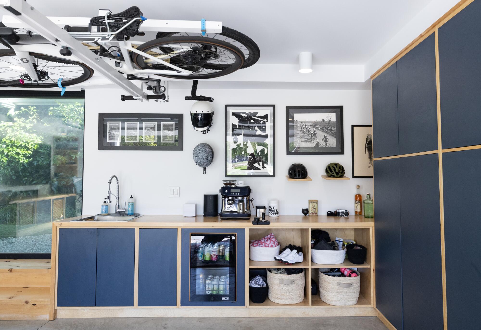 A garage with bikes on the ceiling and blue cabinets 