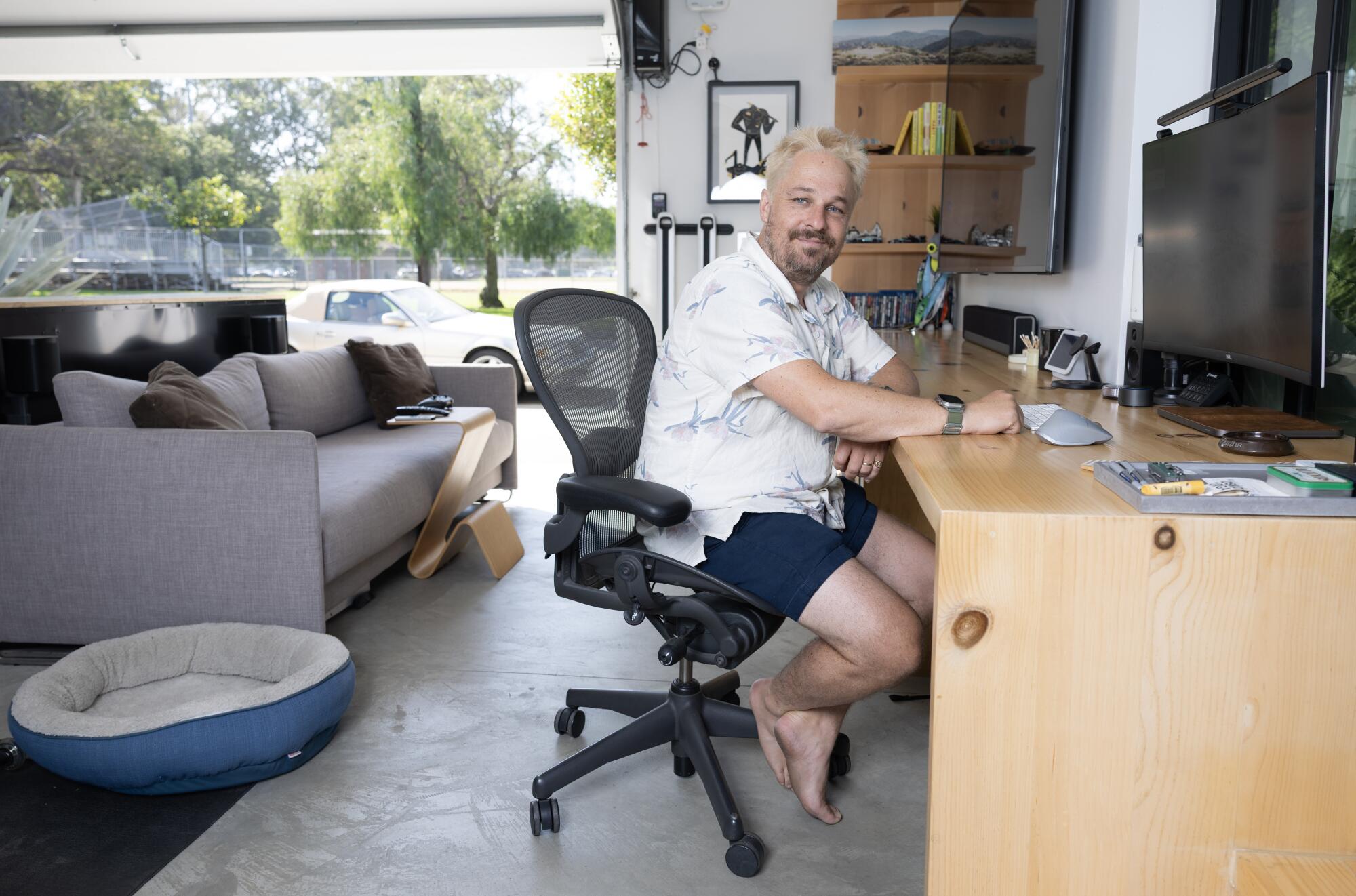 Will Burroughs sits at his des in his garage