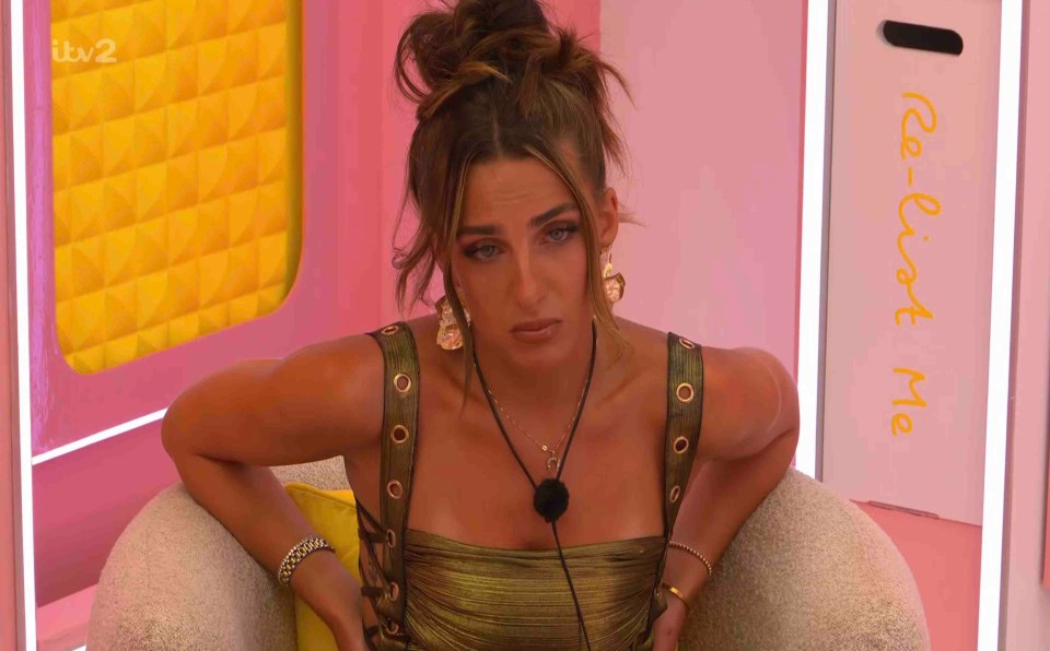 A woman sits in a chair looking upset.