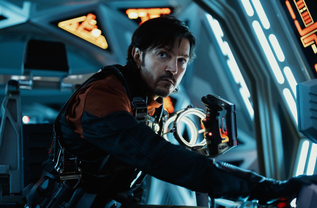 A man wearing an armored suit looks into the distance