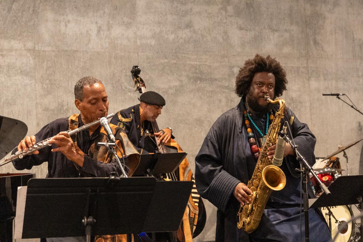 A flutist, a bass player and saxophonist perform.