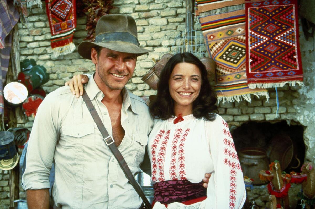 A strapping man in a fedora and a smiling woman pose for the camera.